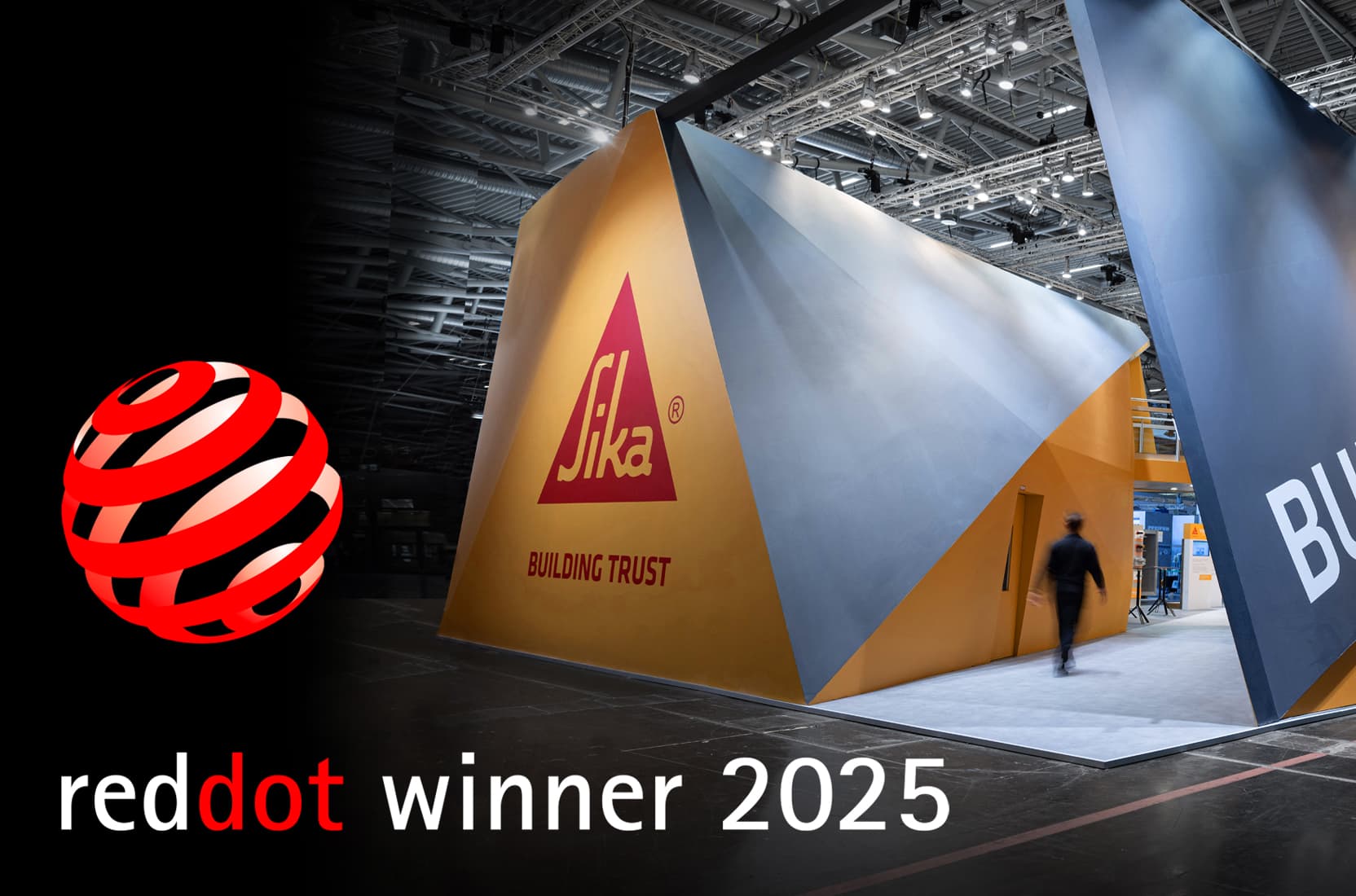 Das Logo des Red Dot Design Award 2025 neben dem preisgekrönten Messestand von Sika auf der Messe Bau 2025