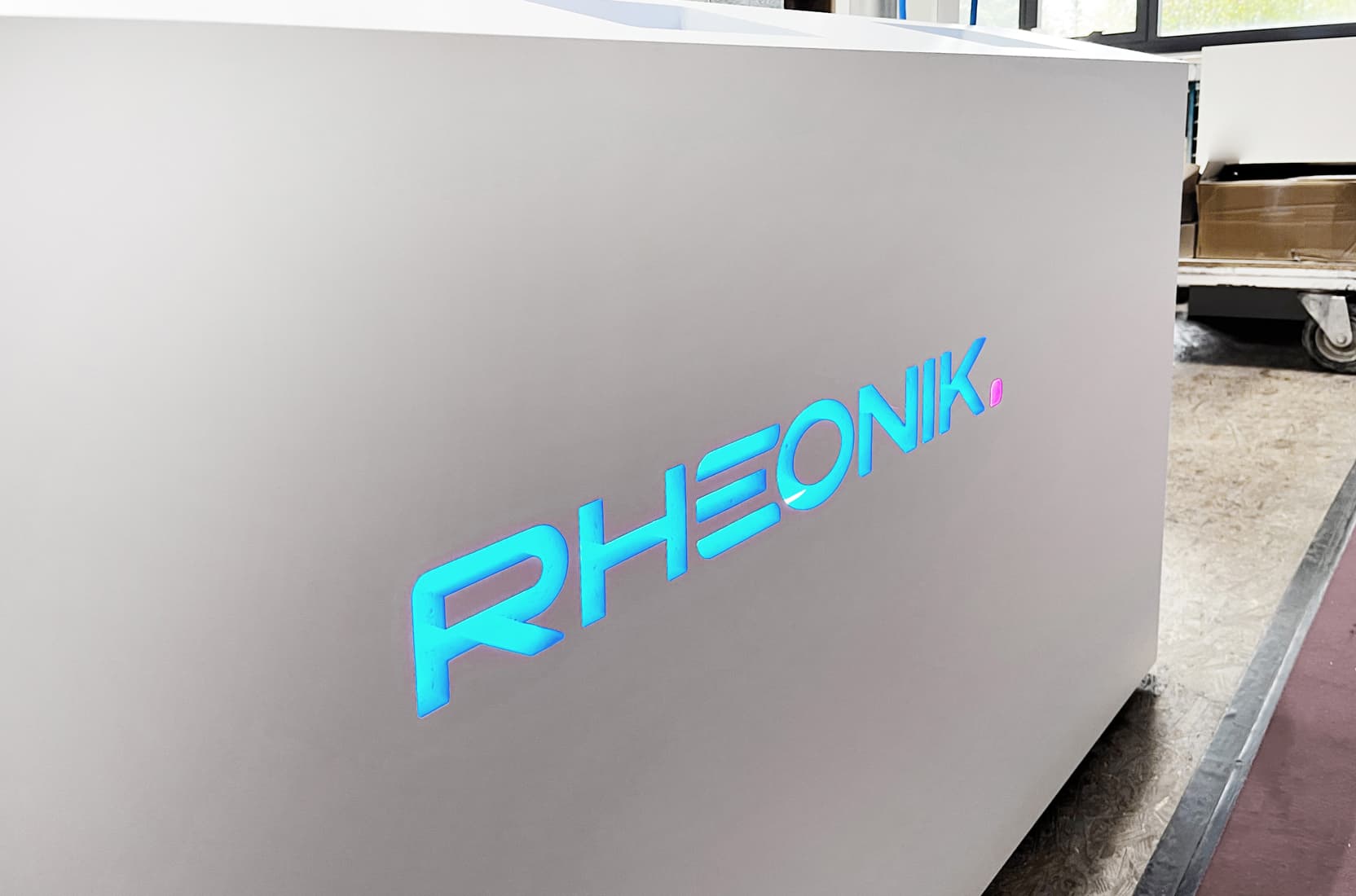 gefräster, LED-hinterleuchteter Logo-Schriftzug auf einem Exponatsockel