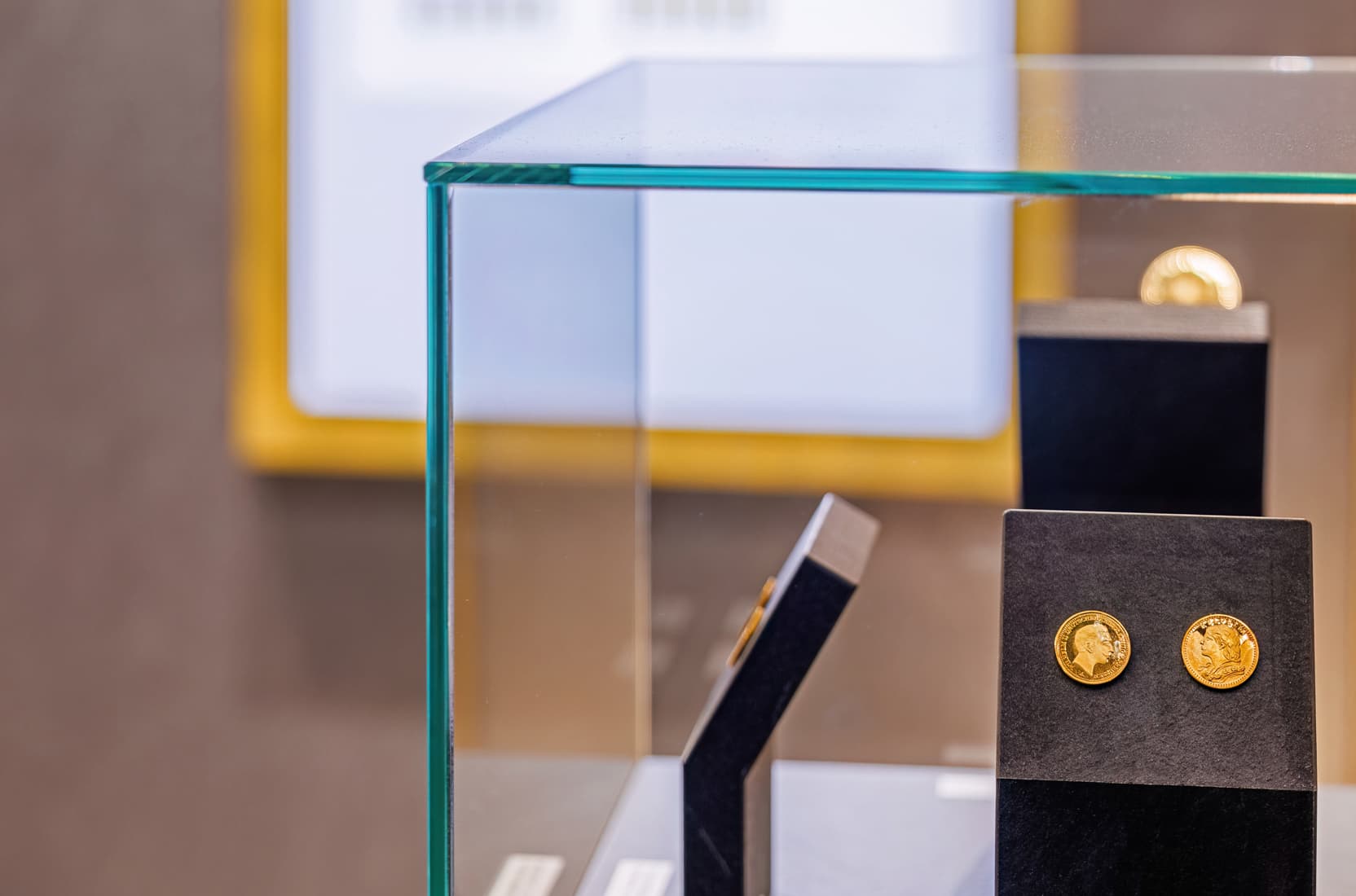 Detailaufnahme einer Vitrine mit Goldmünzen auf einer Wanderausstellung zum Thema Gold