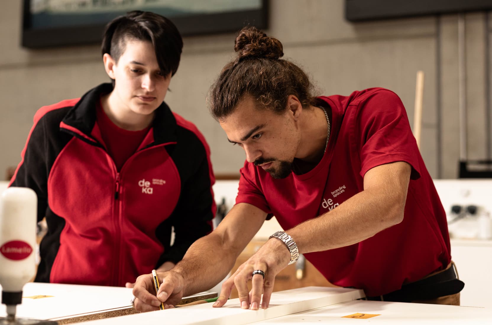 Schreiner und Schreinerin bei der Arbeit in der Werkstatt von deka messebau